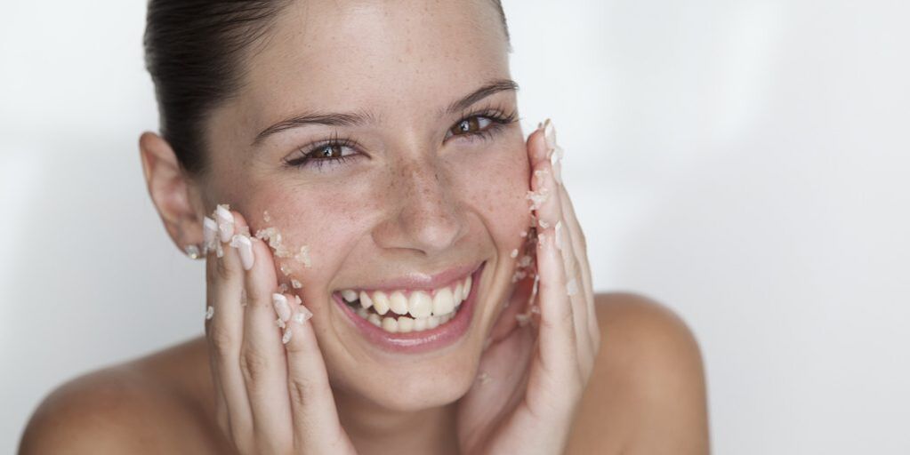 The girl prepares the skin for rejuvenation by using peeling at home